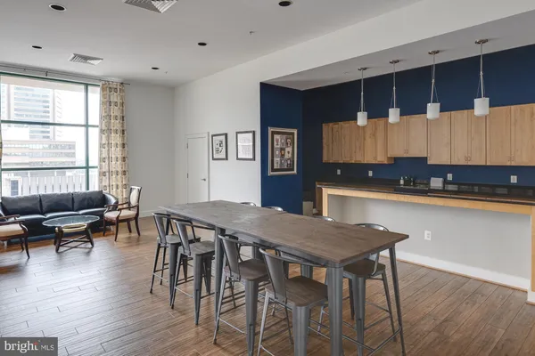 a kitchen with granite countertop a table chairs a sink dishwasher stove and cabinets with wooden floor