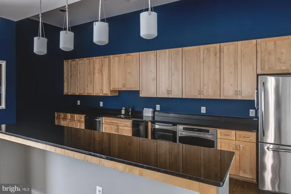 a kitchen with stainless steel appliances granite countertop a refrigerator and a stove