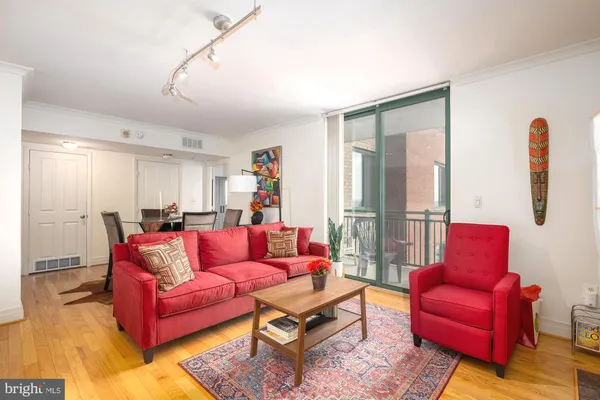 a living room with furniture kitchen view and a large window