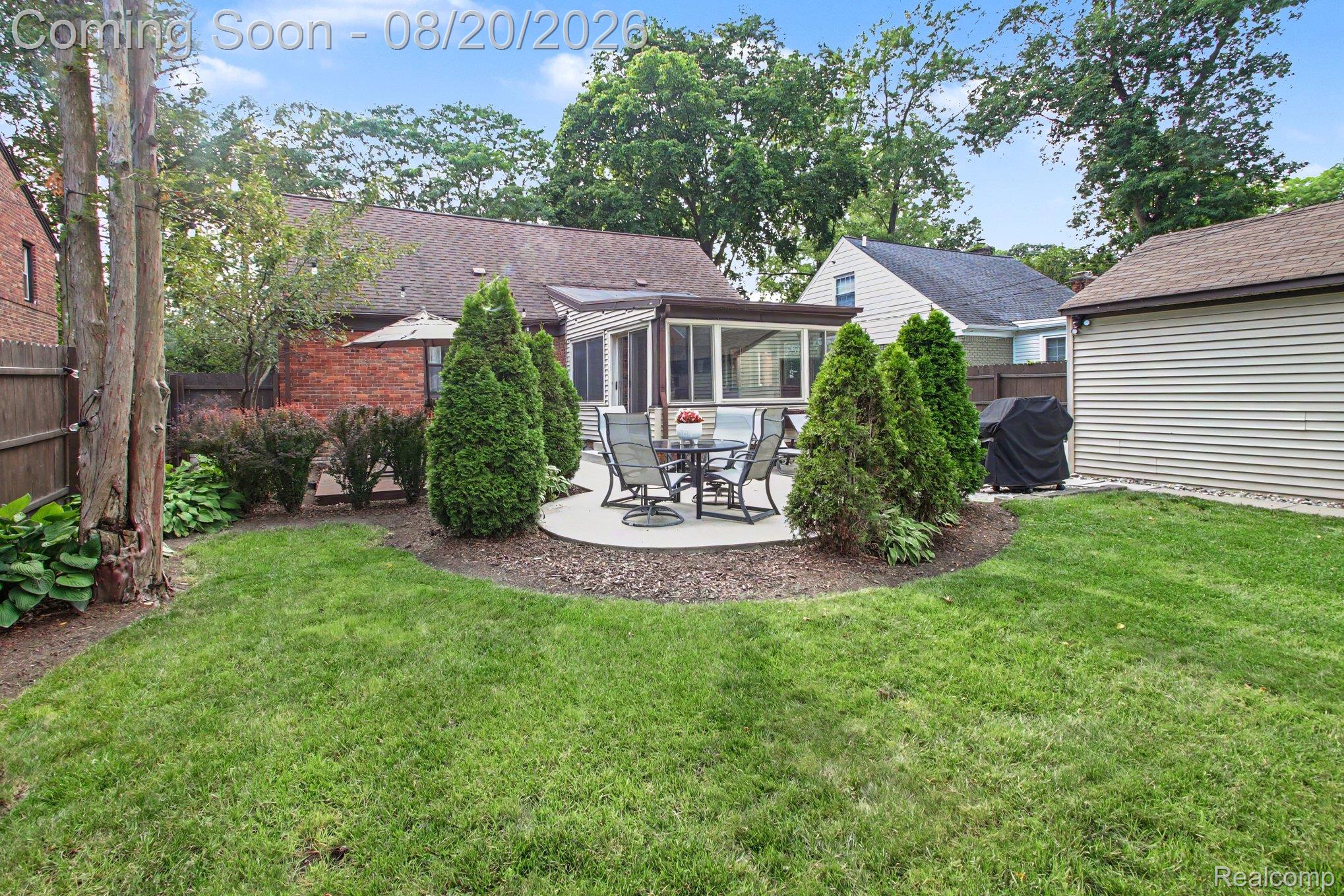 4098 Wakefield Road Berkley, MI 48072 - Photo 42 of 49 Expansive lawn with a circular paved patio, mature landscaping, and a detached structure with horizontal siding