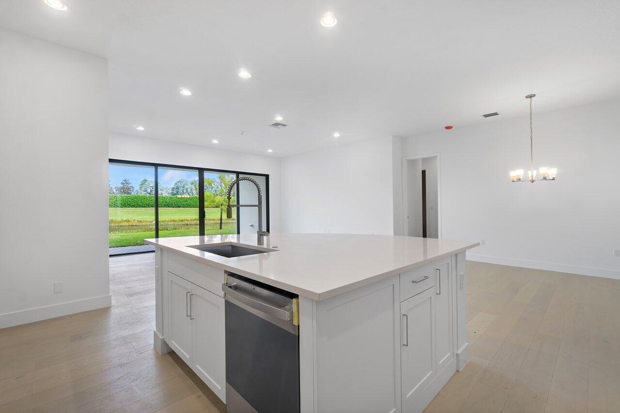 17291 Rainstream Road Boca Raton, FL 33496 - Photo 6 of 21 a kitchen that has a sink a stove and a large window
