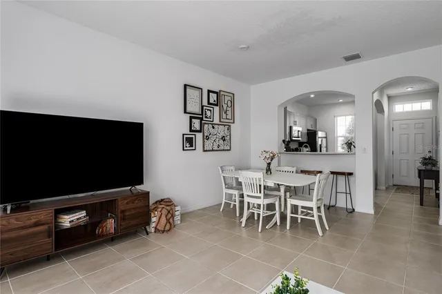 a dining room with furniture and a flat screen tv