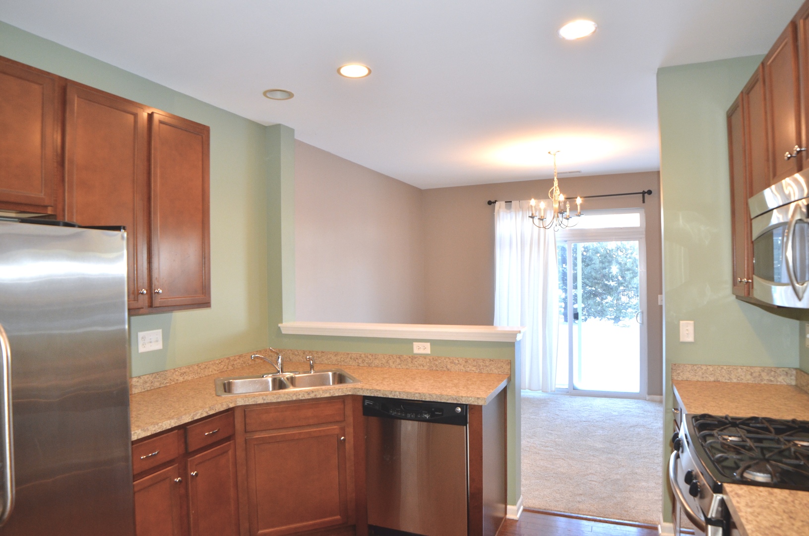 423 Azalea Street Elgin, IL 60124 - Photo 5 of 21 a kitchen with stainless steel appliances granite countertop a sink and a refrigerator