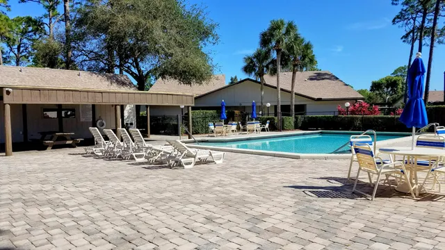 a patio with a table and chairs under an umbrella