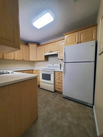 a kitchen with a refrigerator sink stove and cabinets