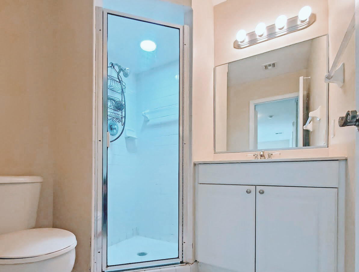 2821 Stoneway Lane, Unit A Fort Pierce, FL 34982 - Photo 9 of 14 a bathroom with a toilet a sink and mirror