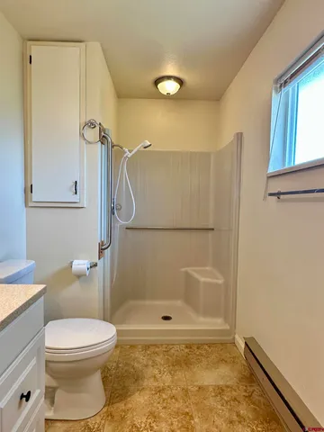 a bathroom with a toilet and a shower
