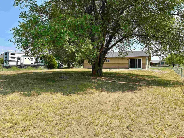 a view of a house with a yard and sitting area