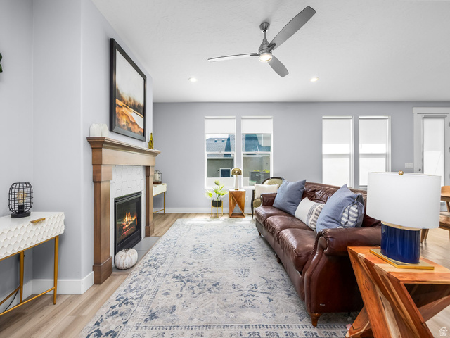 877 South Yarrow Drive Mapleton, UT 84664 - Photo 2 of 46 Living area featuring wood-finish flooring, a contemporary fireplace with a wood mantle and hexagonal tile surround, multiple windows, recessed lighting, and a ceiling fan