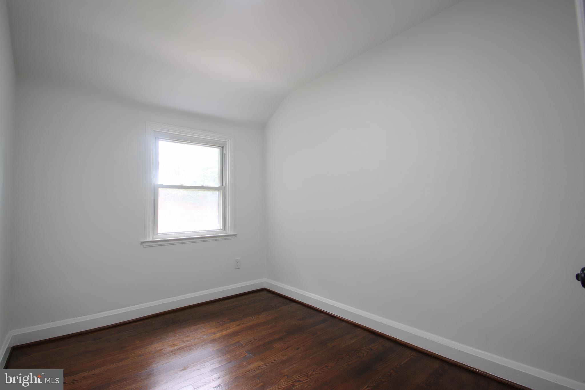 4501 Rokeby Road Baltimore, MD 21229 - Photo 15 of 26 an empty room with wooden floor and windows