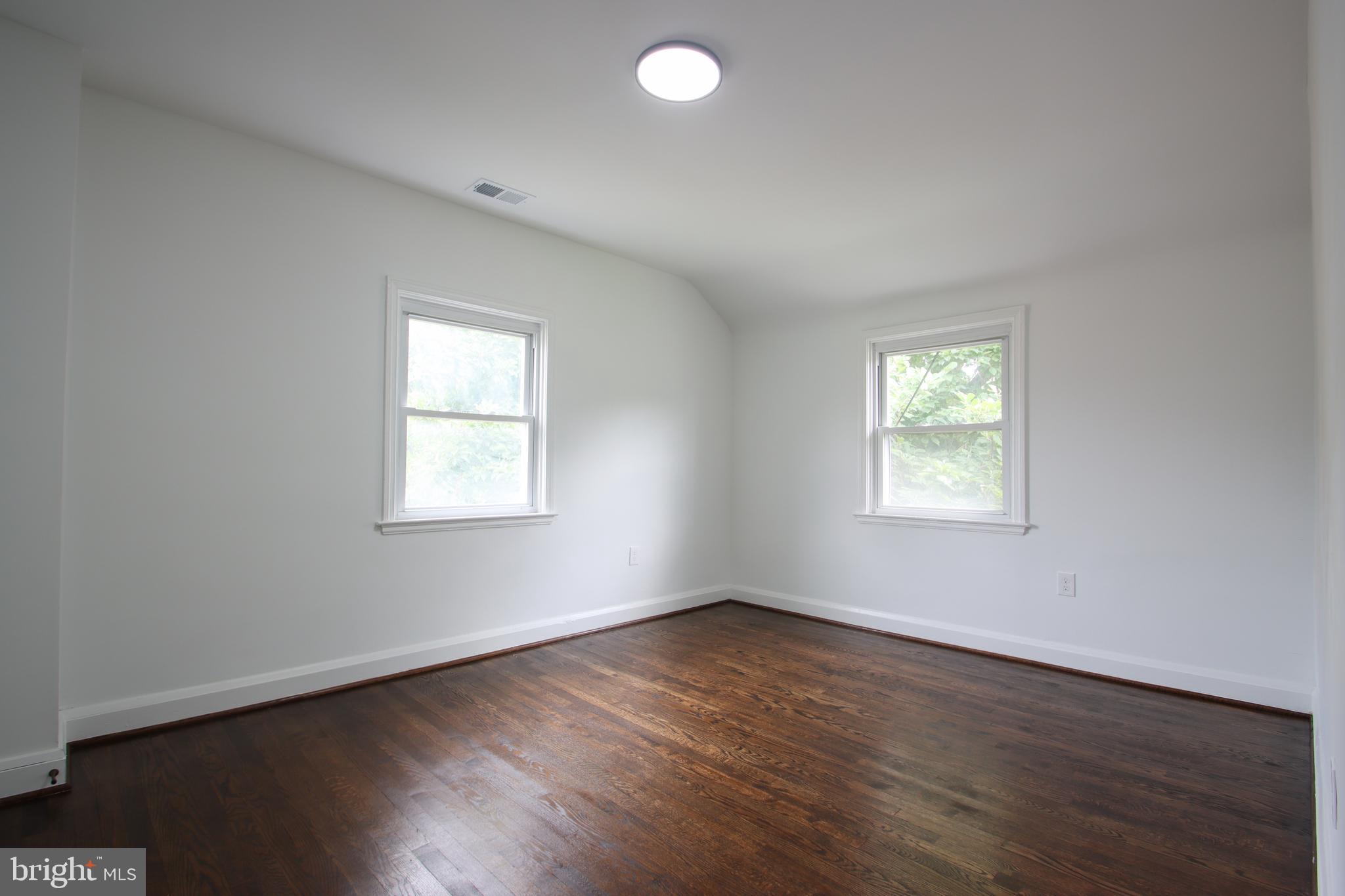 4501 Rokeby Road Baltimore, MD 21229 - Photo 16 of 26 an empty room with wooden floor and windows