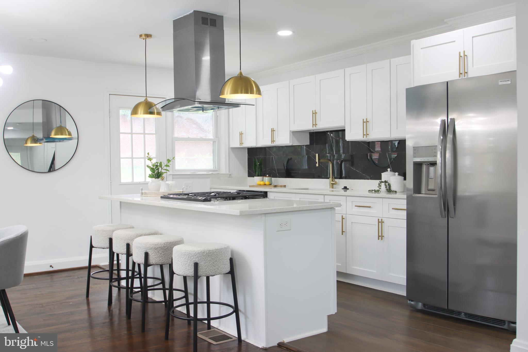 4501 Rokeby Road Baltimore, MD 21229 - Photo 4 of 26 a kitchen with stainless steel appliances a table chairs refrigerator and cabinets