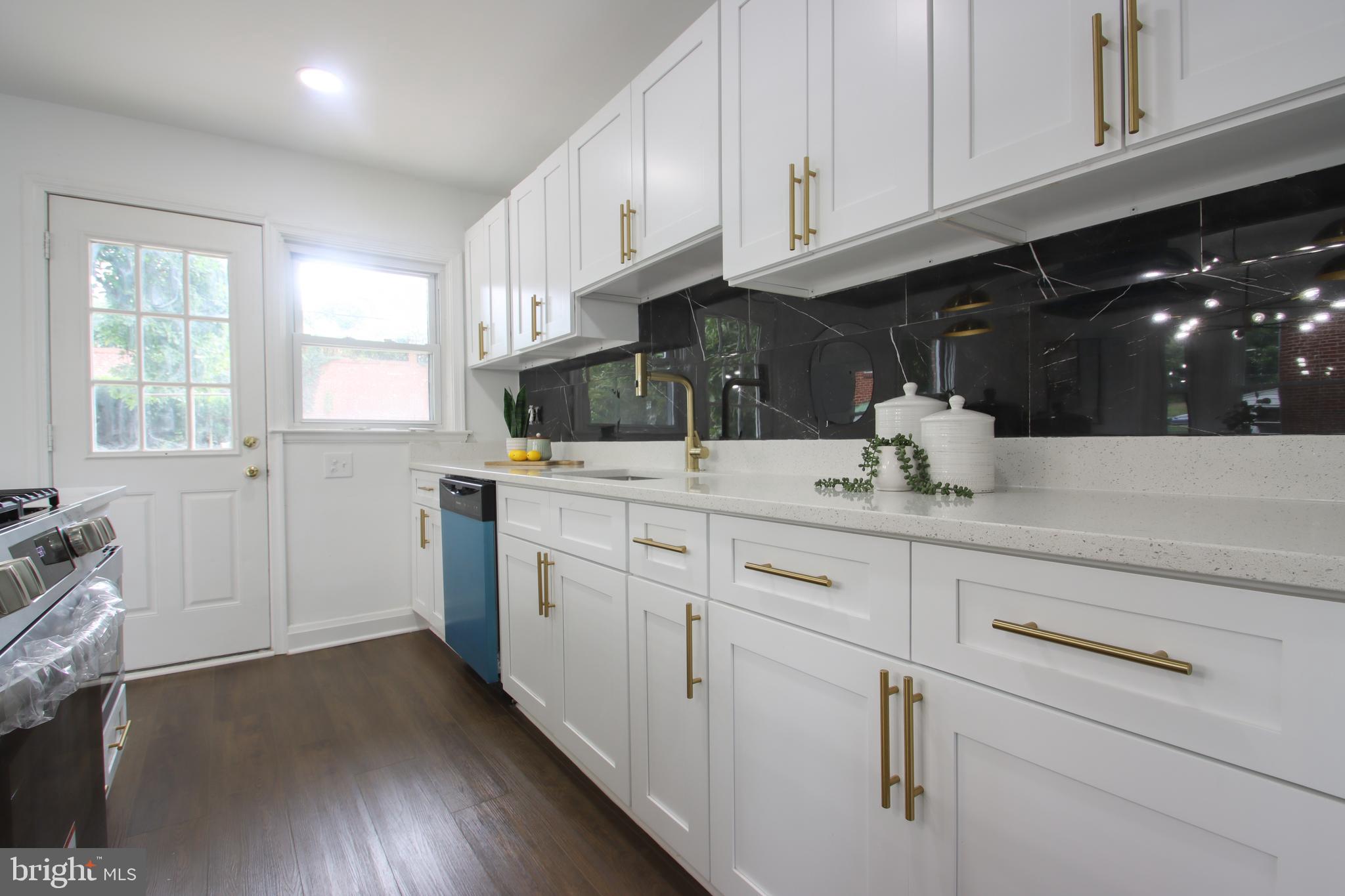 4501 Rokeby Road Baltimore, MD 21229 - Photo 8 of 26 a kitchen with granite countertop white cabinets and white appliances