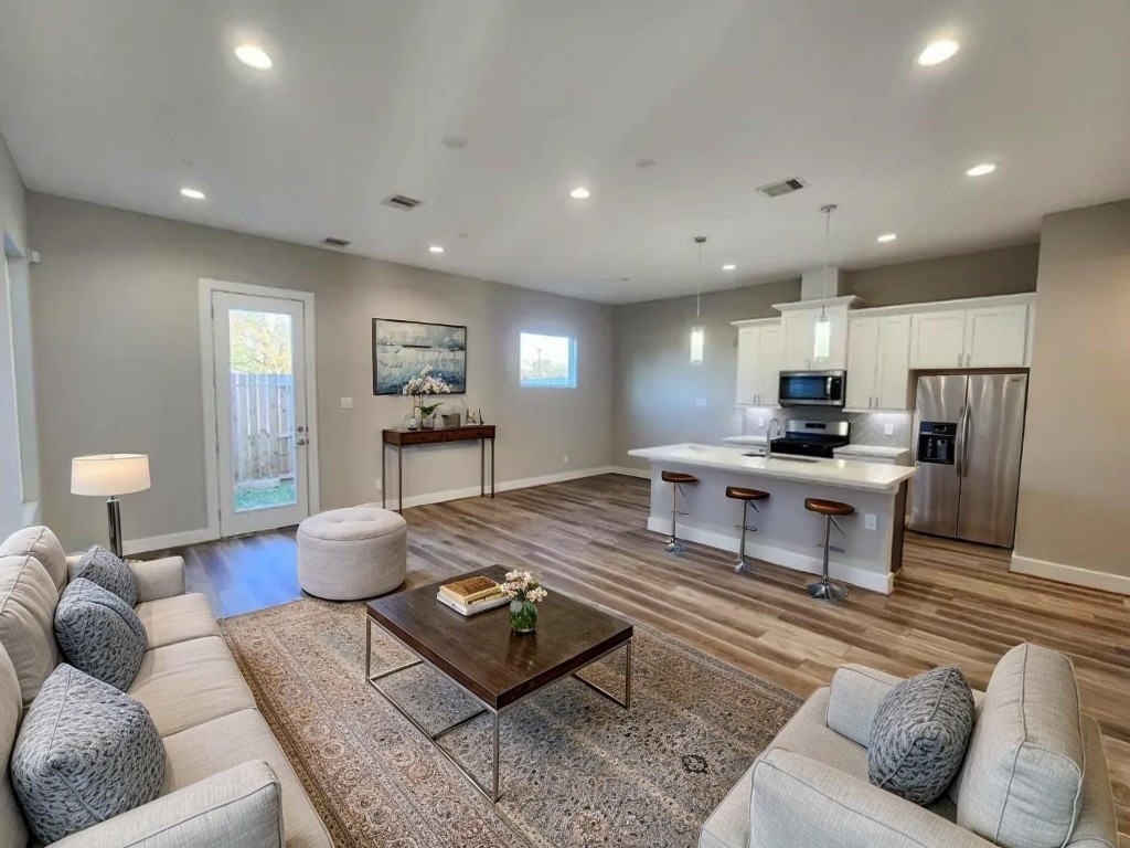 3206 Bostic Street Houston, TX 77093 - Photo 6 of 28 a living room with furniture a wooden floor and kitchen view