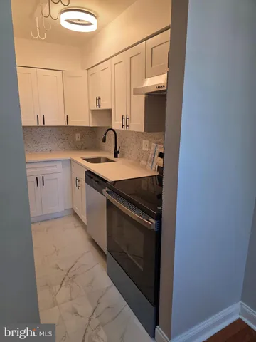 a kitchen with stainless steel appliances granite countertop a sink and a stove