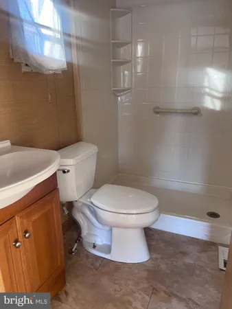 a white toilet sitting next to a bath tub and a shower