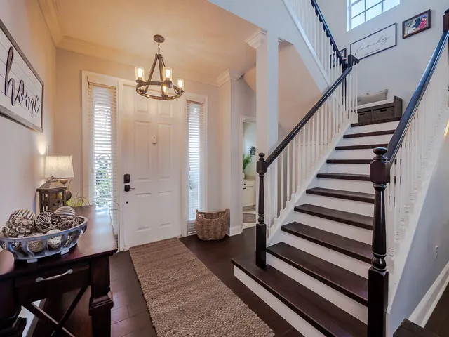 a view of a hallway with wooden floor and stairs