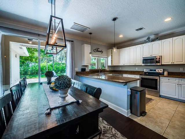 a kitchen with kitchen island granite countertop a stove a sink and a refrigerator