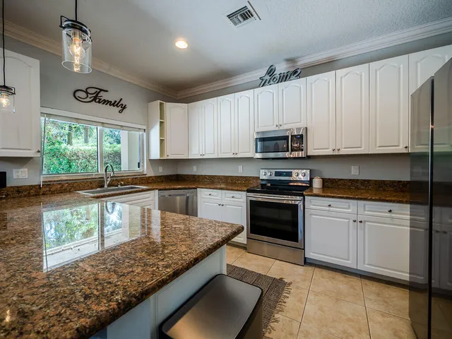 a kitchen with granite countertop a stove sink and microwave