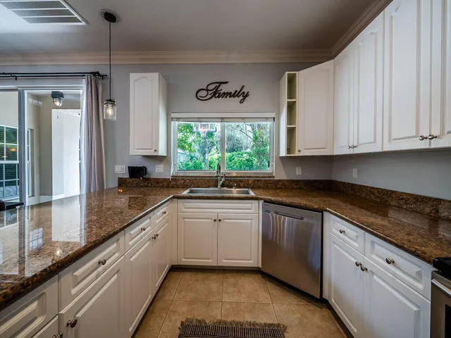 a kitchen with stainless steel appliances granite countertop a sink a stove and cabinets