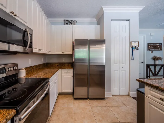 a kitchen with stainless steel appliances granite countertop a refrigerator and a stove