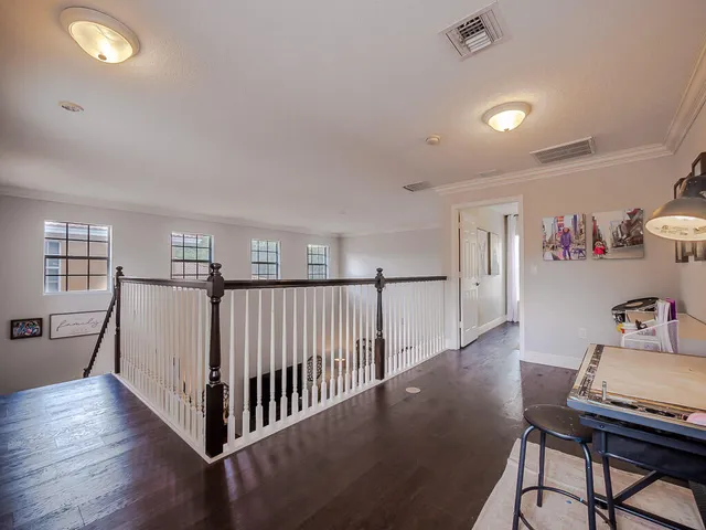 a view of a hallway with furniture and wooden floor