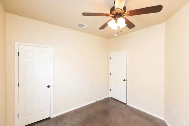 an empty room with a ceiling fan and a fan
