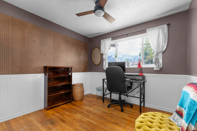 9902 South Poppy Lane Sandy, UT 84094 - Photo 9 of 25 Room featuring wood-finish flooring, wainscoting, a full wall of pegboard, and a ceiling fan