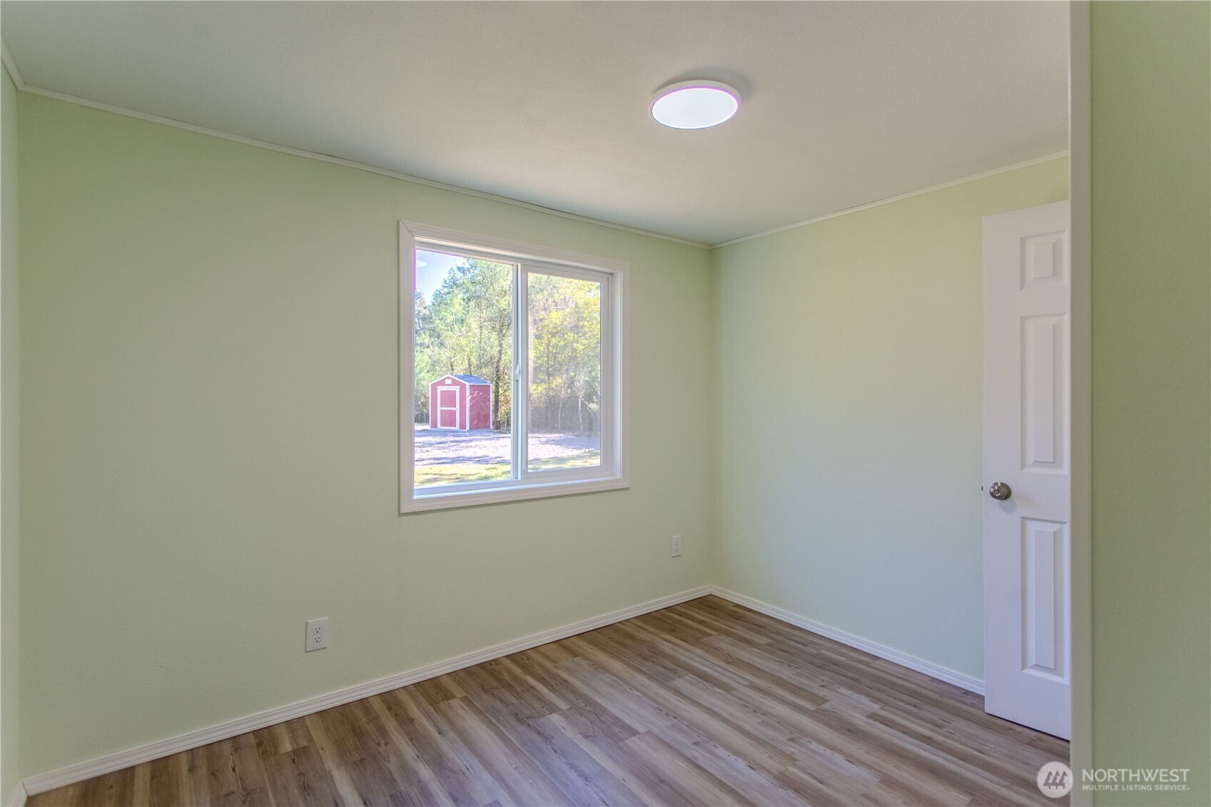 17340 Sargent Road Southwest, Unit 35 Rochester, WA 98579 - Photo 14 of 25 an empty room with wooden floor and windows