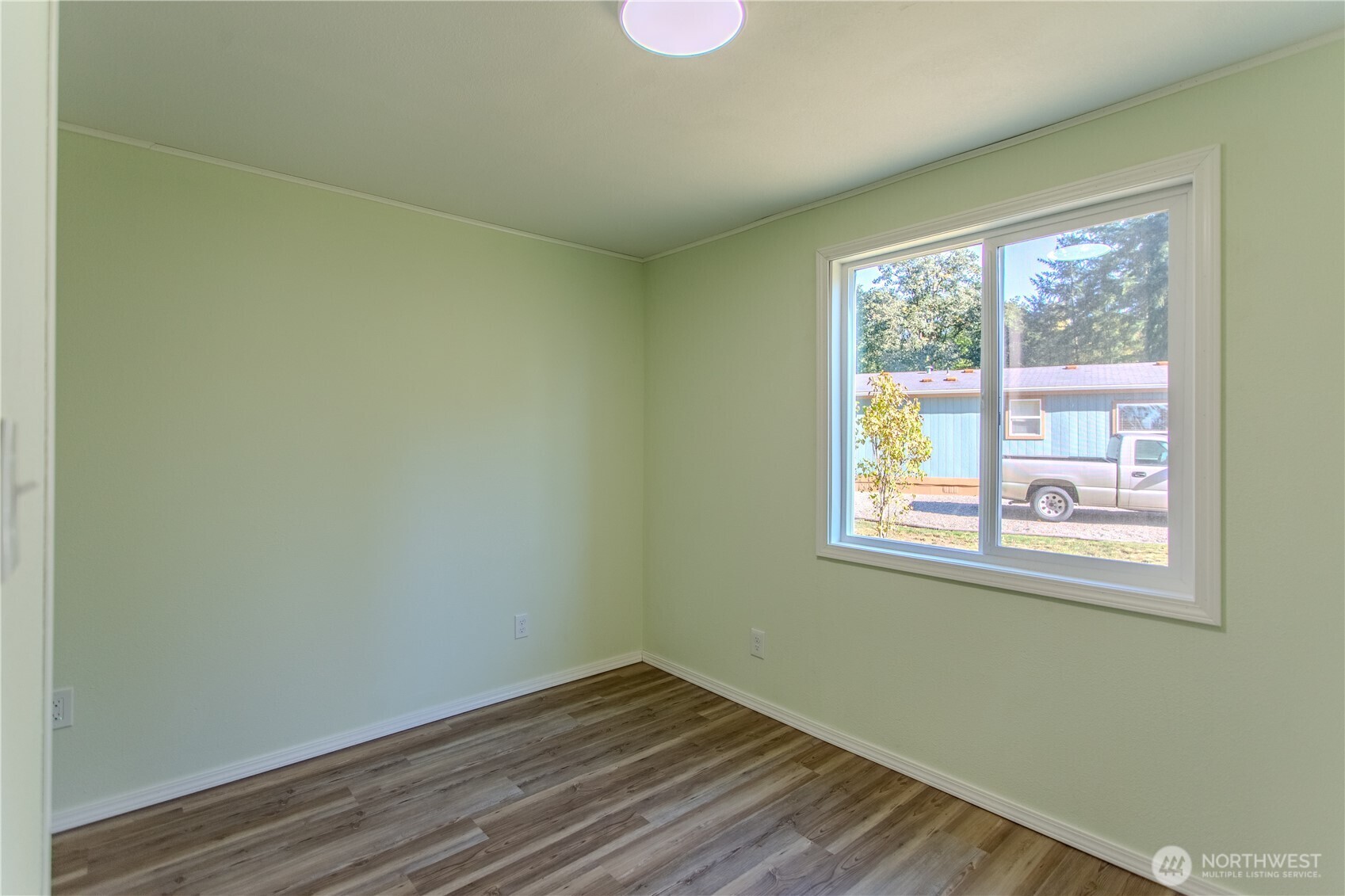17340 Sargent Road Southwest, Unit 35 Rochester, WA 98579 - Photo 17 of 25 a view of an empty room with wooden floor and a window