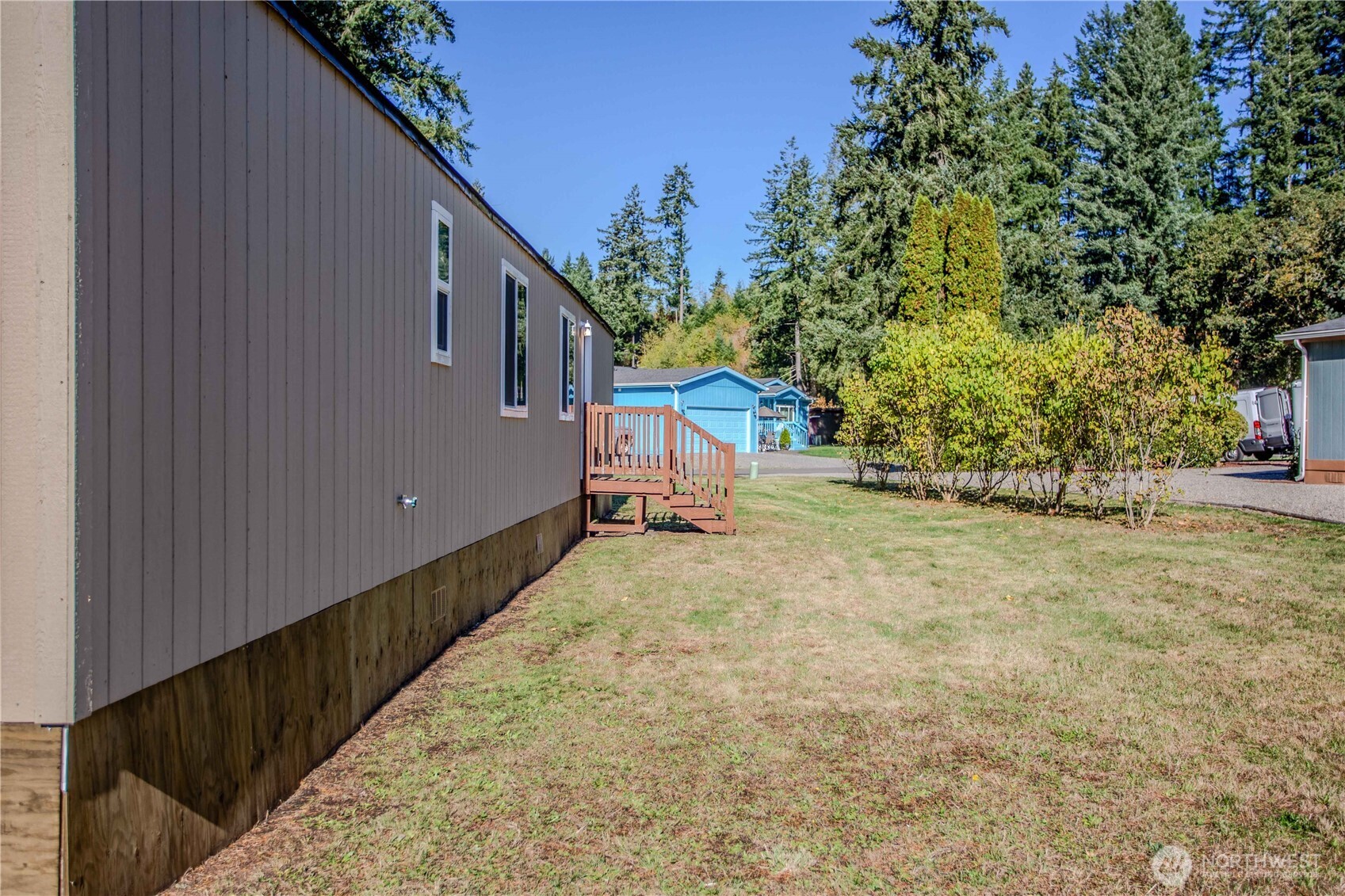 17340 Sargent Road Southwest, Unit 35 Rochester, WA 98579 - Photo 25 of 25 a backyard of a house with wooden fence and trees