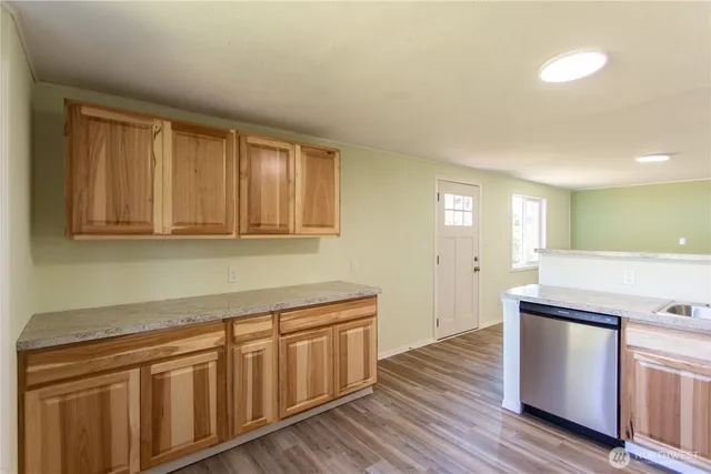 a kitchen with wooden floors and white cabinets
