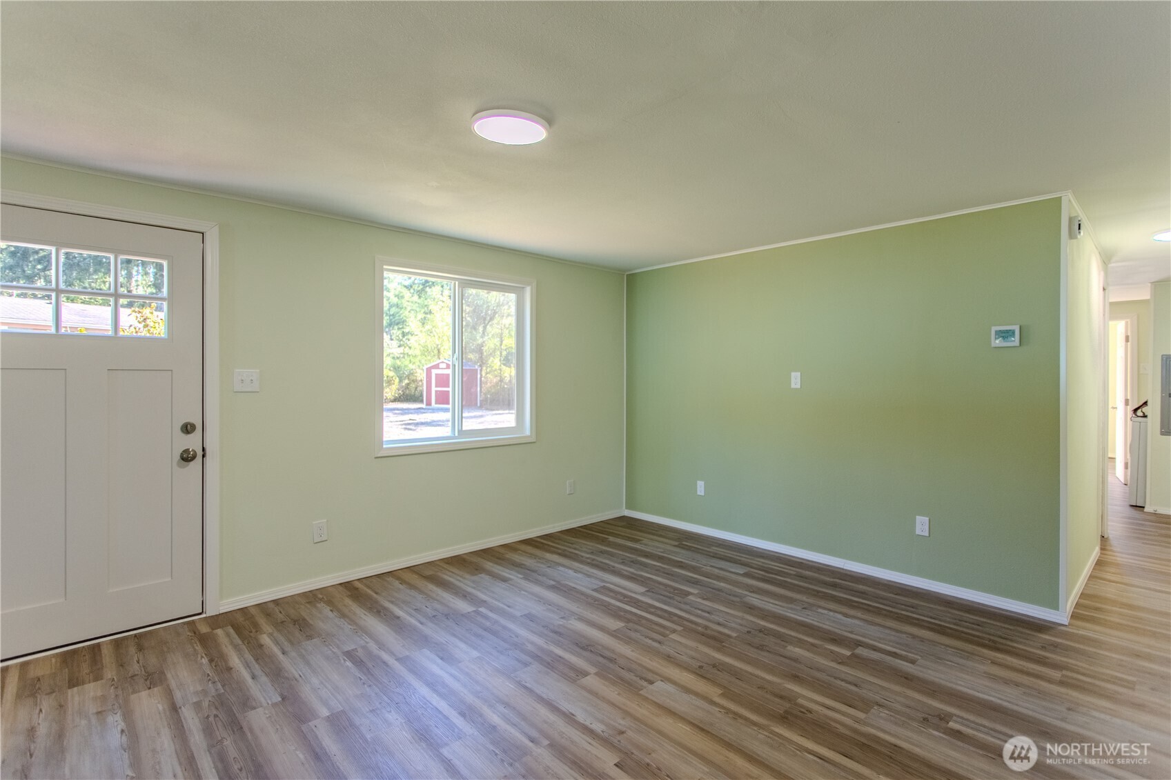 17340 Sargent Road Southwest, Unit 35 Rochester, WA 98579 - Photo 7 of 25 an empty room with wooden floor and windows