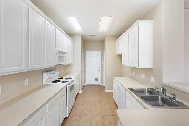 a kitchen with granite countertop a sink stove and cabinets