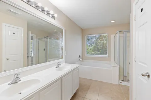 a spacious bathroom with a bathtub shower sink and mirror
