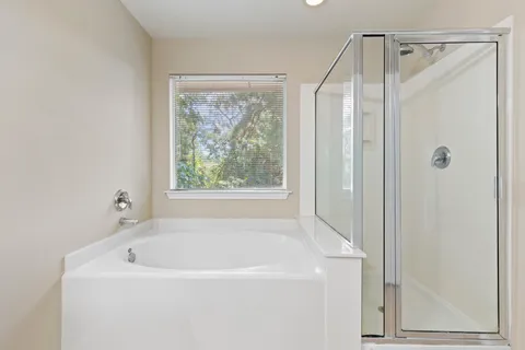 a white bath tub sitting next to a shower
