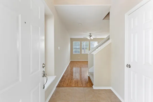 a view of a hallway with wooden floor and staircase