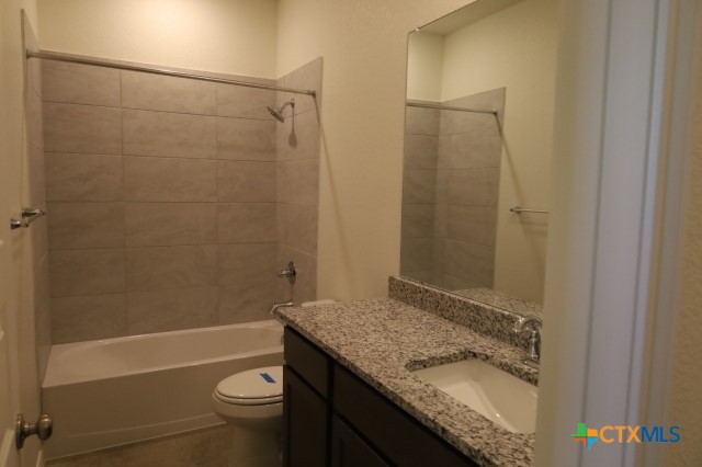 2916 Wildcat Rdg Road, Unit B Temple, TX 76501 - Photo 26 of 39 a bathroom with a granite countertop bathtub shower sink vanity and toilet