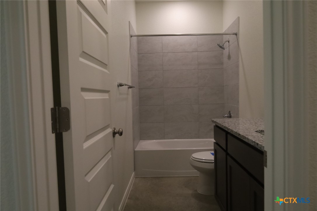2916 Wildcat Rdg Road, Unit B Temple, TX 76501 - Photo 31 of 39 a bathroom with a granite countertop toilet a sink and shower
