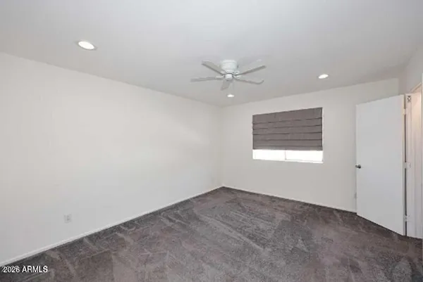 an empty room with a window and ceiling fan