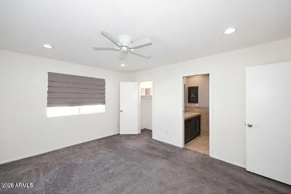 a view of an empty room with closet and a window