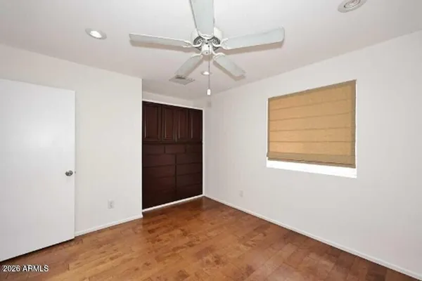 an empty room with a window and a fan