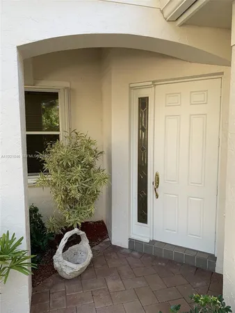 a view of a hallway to a livingroom with furniture and an empty room