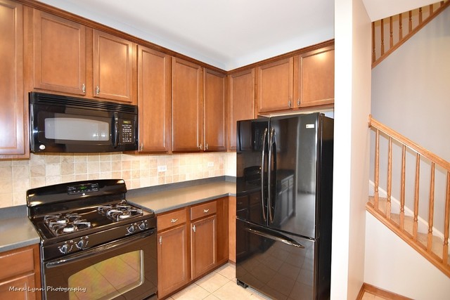 427 Acushnet Street Elgin, IL 60124 - Photo 11 of 26 a kitchen with granite countertop a refrigerator stove and microwave