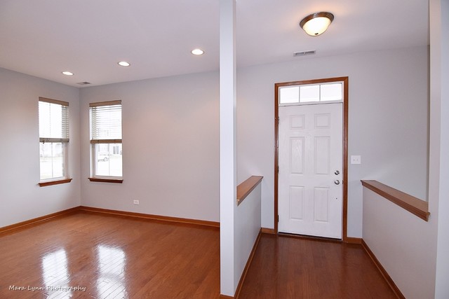 427 Acushnet Street Elgin, IL 60124 - Photo 4 of 26 wooden floor in an empty room with a window