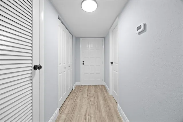 a view of a hallway with wooden floor
