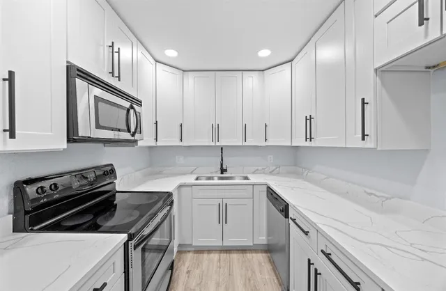 a kitchen with stainless steel appliances a sink stove and cabinets