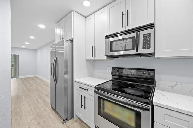 a kitchen with stainless steel appliances granite countertop a stove microwave and refrigerator