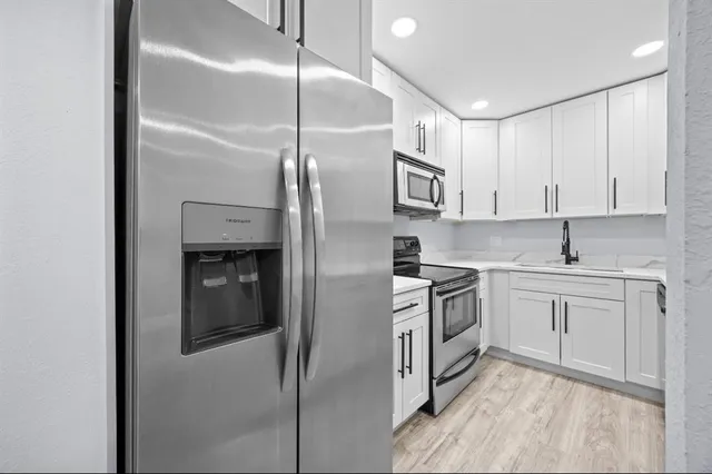 a kitchen with cabinets and stainless steel appliances