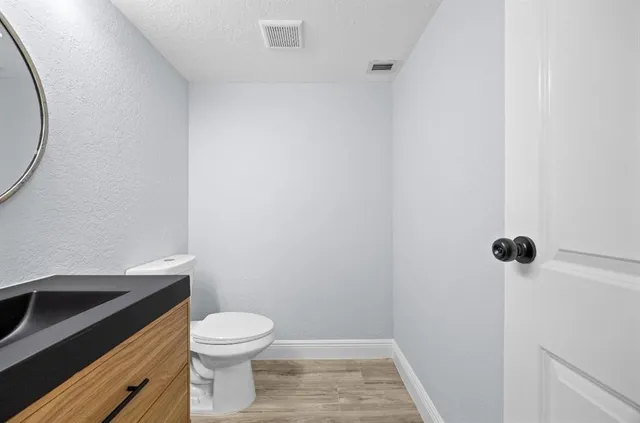 a bathroom with a granite countertop toilet and a sink